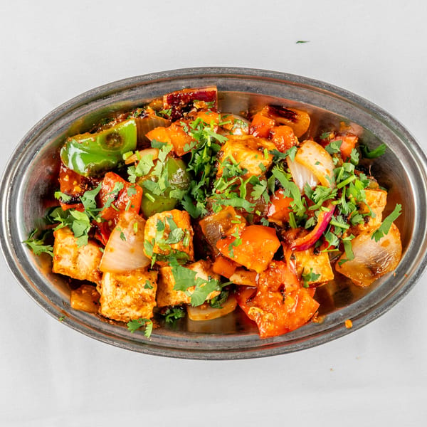 Chili Paneer, a vibrant Indian dish with paneer, bell peppers, and onions, garnished with cilantro.